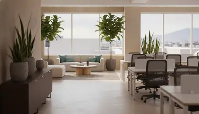 Oficina abierta con sillas de malla negra, escritorios y sala de espera junto a ventanales